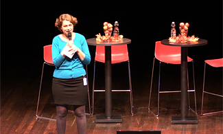 Bild på Anna-Karin Klomp som står på scen och föreläser