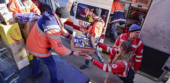 Personal arbetar med att dela ut lådor med mat till personer som har sökt skydd.