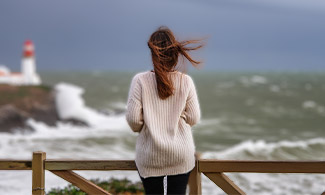 En kvinna ser ut över ett stormigt hav