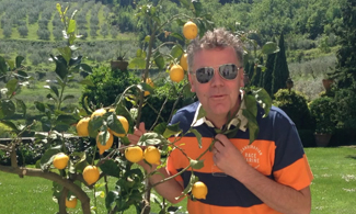 Bild på Claes som står vid ett citronträd.
