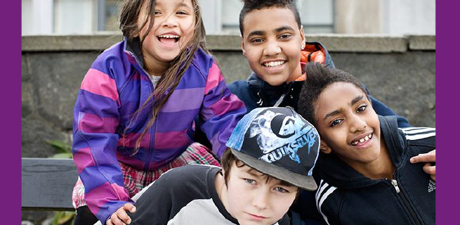 Fyra barn som ler in i kameran