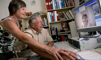 En kvinna och en äldre man som sitter i ett videosamtal på datorn.