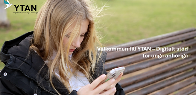 En tjej sitter med sin mobiltelefon. 