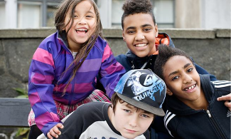 Fyra barn som ler in i kameran