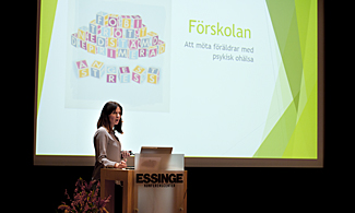 Bild på Höylo Olsen som står på scen och föreläser