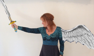 Bild på en kvinna med målad vinge och håller i ett målat svärd.