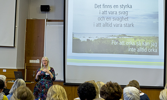 Bild på Jenny Eriksson som föreläser på scen framför deltagarna