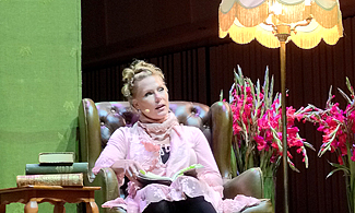Bild på Marlene Lund som sitter i en fåtölj på scen
