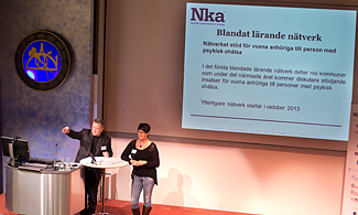 Bild på konferens scenen där två personer föreläser