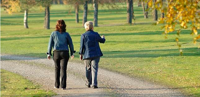 Två kvinnor går längs en väg tillsammans