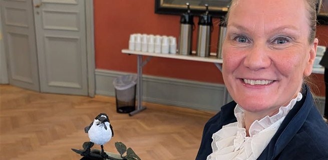 Bild på Åsa som tar emot ett pris i form av en fågel