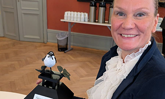 Bild på Åsa som tar emot ett pris i form av en fågel