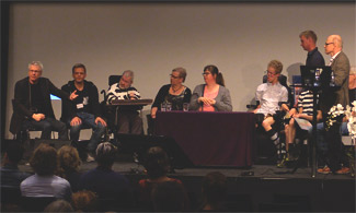 Bild på flera personer som sitter på scen