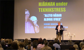 Bild på Nils Simonsson som står på scen och föreläser