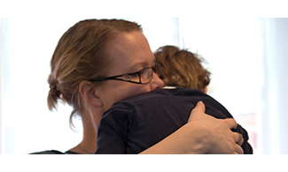  Bild på en förälder som kramar sitt barn