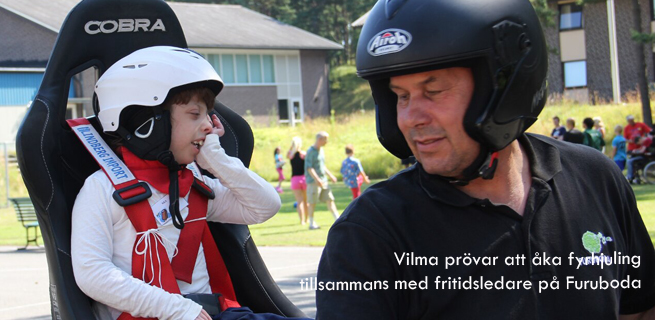 Vilma åker fyrhjuling tillsammans med en fritidsledare.