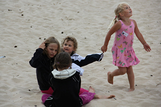 Barn leker på stranden.