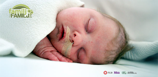 Nyfödd ligger på en filt med projektekts logotyper