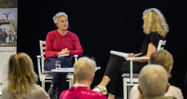 Fanny Ambjörnsson sitter på scen tillsammans med moderator MariaAhlqvist.