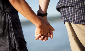 Ett par håller varandras händer