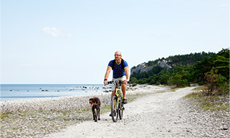 En man cyklar tillsammans med sin hund
