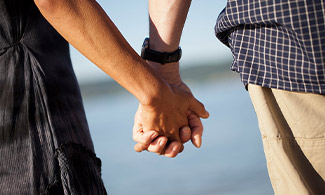 Två personer håller varandra i handen